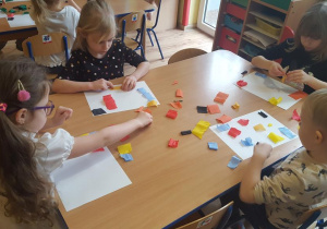 Dzieci układają skrawki bibuły.